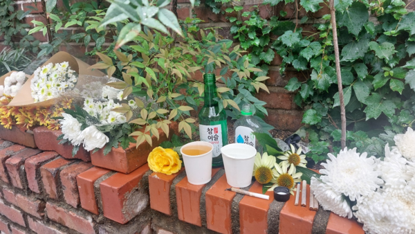 발인 하루 전날 이른 오후, 학전소극장 담벼락 앞 축대에는 ‘아침이슬’을 생각나게 하는 소주병과 누군가 따라 놓은 맥주 잔, 불을 붙여 놓았던 담배 개비가 비에 젖고 있었다. © 이봉수