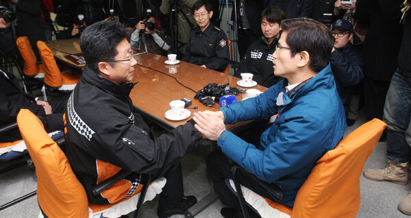 김문수 경기도지사가 30일 오전 경기도 남양주시 평내동 남양주소방서에서 자신의 전화에 대해 해명한 뒤 오윤석 소방위(왼쪽)의 손을 잡고 있다. 남양주소방서의 오윤석 소방위와 윤경선 소방교는 지난 19일 김 지사의 전화를 장난전화로 판단해 응대를 잘못했다는 이유로 문책성 전보조치를 당했다가 김 지사 비난 여론이 커지자 지난 29일 원대 복귀했다. 2011.12.30. 연합뉴스 자료사진