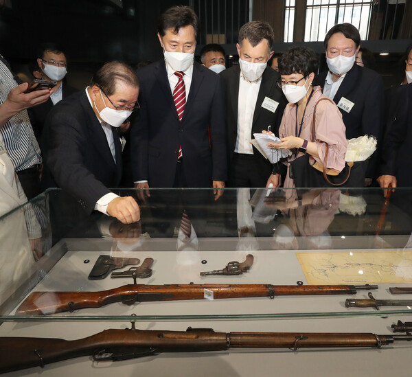 윤석열 전 검찰총장(오른쪽)이 2021년 6월 서울 중구 남산예장공원 내에 있는 우당 기념관 개관식에 참석.이회영 선생의 후손인 이종찬 대한민국임시정부기념관 건립위원장(왼쪽)의 안내로 봉오동·청산리전투때 사용된 옛 체코군단의 소총을 살펴보고 있다. 연합뉴스