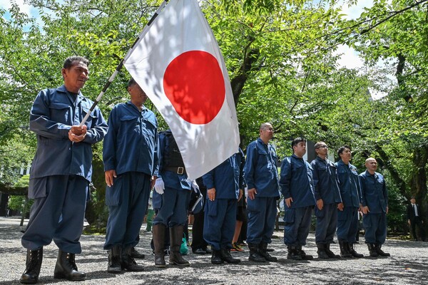 8월 15일, 일본이 2차 세계대전에서 항복한 지 79주년을 맞아 도쿄의 야스쿠니 신사 경내에 모인 우경단체 회원들이 일본 국기를 들고 참배하고 있다. 2024.8.15. AFP 연하뉴스