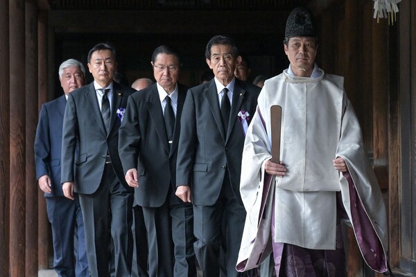 일본 국회의원들이 8월 15일, 일본의 2차 세계대전 항복 79주년을 맞아 도쿄의 야스쿠니 신사를 참배하기 위해 신토 사제(오른쪽)를 따라가고 있다. 2024.8.15. AFP 연합뉴스