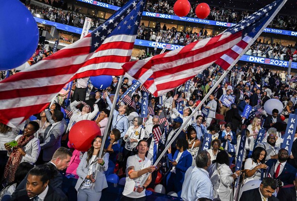 22일 미국 민주당 전당대회가 열린 일리노이주 시카고의 유나이티드 센터에서 참석자들이 카멀라 해리스의 후보 수락 연설이 끝난 뒤 자리에서 일어나 대형 성조기를 흔들고 있다. 2024.8.22. AFP 연합뉴스