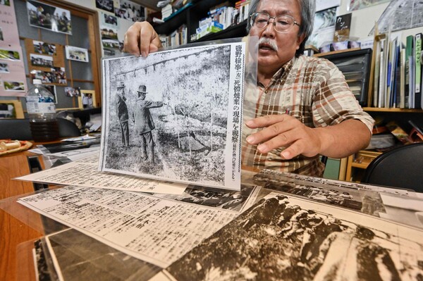 1923년의 관동대지진 때 일본인들 손에 학살당한 조선인 문제를 추적해 온 일본 시민단체 호센카 재단의 니시자키 마사오 이사가 조선인 학살 관련 사진을 들고 있다. 흑백사진 속의 검사가 가리키는 곳이 학살당한 조선인들을 집단매장한 도쿄 아라카와 강변이다. 2023.-06.21. AFP 연합뉴스