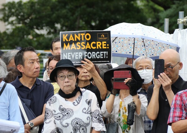1일 일본 도쿄 스미다구 요코아미초공원에서 열린 간토대지진 101주년 조선인 희생자 추도식에서 한 참가자가 영어로 '간토대학살 잊지 말라'라고 적힌 종이를 들고 있다. 이날 행사는 간토대지진 당시 학살된 조선인을 추도하기 위해 열렸다. 2024.9.1. 연합뉴스