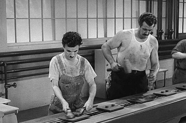 영화 에서 컨베이어 벨트의 속도에 맞춰 기계처럼 일하는 노동자의 모습.