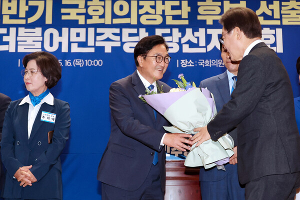 더불어민주당 국회의장 후보로 선출된 우원식 의원이 16일 오전 국회 의원회관에서 열린 제22대 전반기 국회의장단 후보 선출을 위한 당선자 총회에서 이재명 대표로부터 꽃다발을 받고 있다. 2024.5.16. 연합뉴스