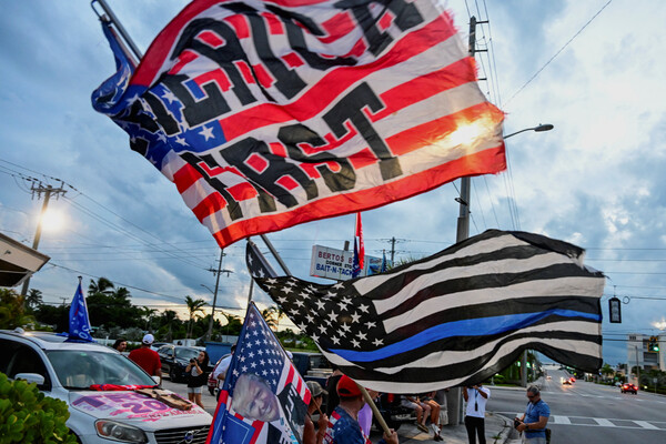도널드 트럼프 전 미국 대통령이 15일 암살 시도를 모면한 뒤 현장 인근인 플로리다주 팜비치 마라라고의 자택 입구에서 지지자들이 깃발을 흔들고 있다. 2024.9.15. 로이터 연합뉴스 
