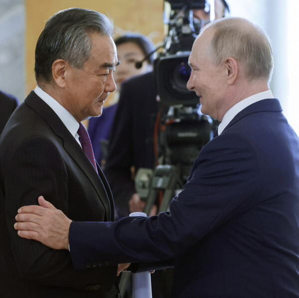 블라디미르 푸틴 러시아 대통령이 12일 생페트르부르크에서 열린 브릭스(BRICS) 국가안보 고위 당국자 회의 도중 참석한 중국의 왕이 외교부장을 환영하고 있다.  2024. 09. 12 [스푸트니크=로이터=연합뉴스]