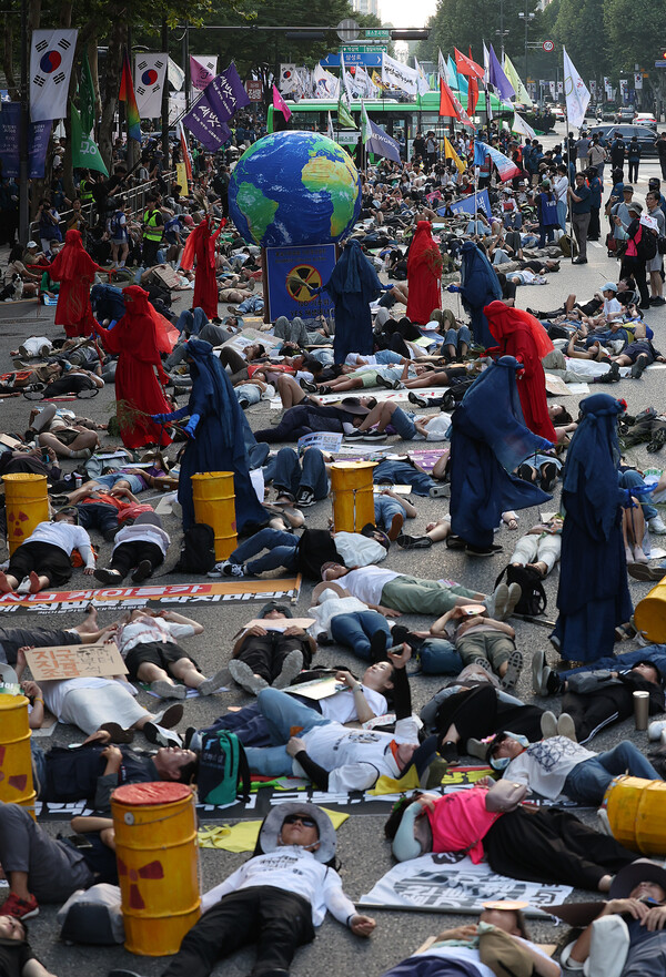지난 7일 오후 서울 강남구 테헤란로에서 펼쳐진 기후정의행진에서 참가자들이 도로 위에 죽은 듯 눕는 '다이인(die-in)' 퍼포먼스를 펼치고 있다. 2024. 9. 7.연합뉴스