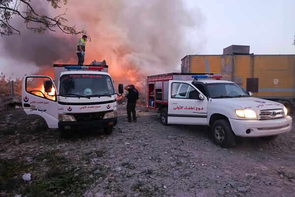 24일 남부 레바논의 아바시예 마을에 대한 이스라엘군의 공습으로 불길이 치솟고 있다. 폭격 현장에서 구조대가 구조 활동을 펼치고 있다. 2024. 09. 24 [AFP=연합뉴스]