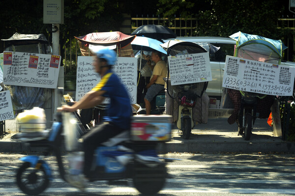 지난 8월 27일 중국 동부 저장성 항저우의 보도를 따라 주차된 전기 스쿠터에 임대 가능한 부동산을 표시하는 플래카드들이 줄지어 진열돼 있다. 2024.8.27. AP 연합뉴스