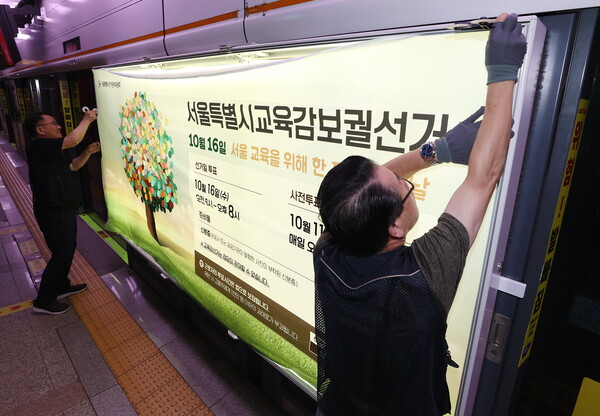 13일 오전 서울 지하철 3호선 충무로역 승강장 스크린 도어에 선관위 관계자들이 오는 10월 16일 실시하는 서울시교육감 보궐선거 홍보물을 부착하고 있다. 2024.9.13. 연합뉴스