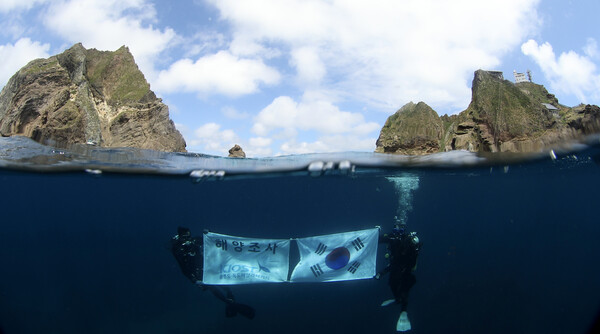 독도 일대를 조사 중인 한국해양과학기술원 울릉도독도해양연구기지 직원들이 광복절을 앞둔 14일 독도의 하늘과 바다를 배경으로 태극기를 펼쳐 보이고 있다. 2024.8.15 [울릉도독도해양연구기지 제공.