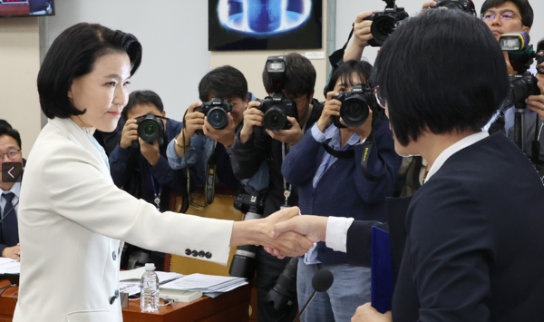 이진숙 방송통신위원장이 7일 오후 국회 과학기술정보방송통신위원회의 국정감사에서 최민희 위원장에게 증인선서문을 전달 후 악수하고 있다. 이 위원장은 야당이 단독 처리한 탄핵소추로 직무가 정지된 상태라 기관 증인이 아닌 일반 증인으로 출석했다. 연합뉴스