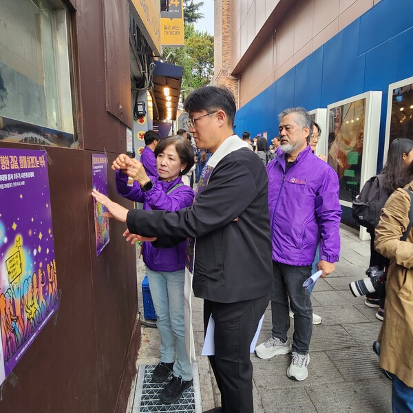 21일 오후 서울 이태원역 1번 출구 앞에서 열린 10.29 이태원 참사 2주기 집중추모주간 선포 기자회견이 끝나고 유가족협의회 관계자들과 박형순 목사가 포스터를 붙이고 있다. 2024.10.21. 김민주 기자