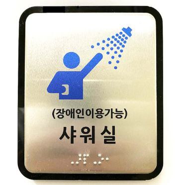  장애인도 이용할 수 있는 샤워실 표지판 아래 점자로도 표시해놓았다.