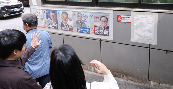 서울시교육감 보궐선거 사전투표 첫날인 11일 중구 소공동 사전투표소에서 유권자들이 공보물을 보고 있다. 2024.10.11. 연합뉴스