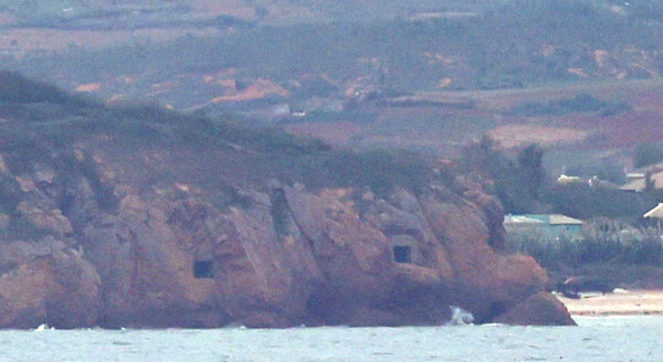 북한 인민군 총참모부가 국경 부근 포병부대에 완전사격 준비태세를 지시한 가운데 14일 황해도 해안의 해안포 포문이 열려 있다. 인천시 옹진군 연평도에서 바라본 장면이다. 2024.10.14. 연합뉴스 