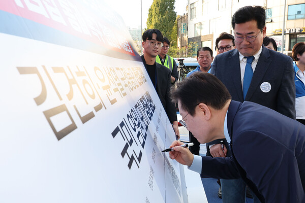 이재명 더불어민주당 대표가 2일 서울 중구 서울역 일대에서 열린 김건희 윤석열 국정농단 규탄·특검 촉구 국민행동의날 집회에서 박찬대 원내대표를 비롯한 주요 참석자들과 함께 김건희·윤석열 국정농단 의혹 진상규명을 위한 특검법 통과 촉구 천만인 서명운동판에 서명하고 있다. 2024.11.2. 연합뉴스