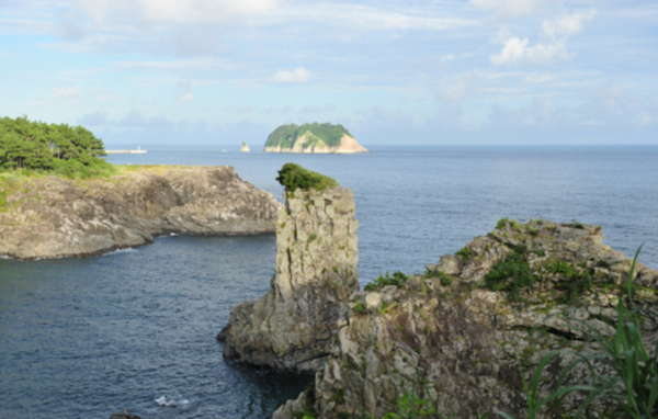 외돌개 뒤로 범섬이 보인다. 최영 장군이 외돌개를 거대한 장수 모습으로 꾸며놓자 범섬으로 달아난 목호들이 겁을 먹고 전의를 상실했다는 전설이 전해진다. [한국관광공사]