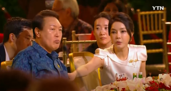 지난 2022년 11월 15일 인도네시아 발리 G20 환영만찬에 참석한 김건희 씨가 가만히 앉아있는 윤석열 대통령에게 '당신도 나가, 나가'라고 말하며 떠미는 장면이 잡혀 화제가 되었다. YTN 영상 갈무리. 