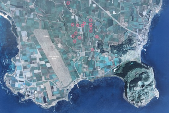 왼쪽 위에 모슬포항이 있고 들판에 길게 뻗어 있는 곳이 알뜨르 비행장 활주로이다. 가운데 붉은 동그라미로 표시된 곳은 격납고. 오른쪽 아래 송악산과 분화구가 보이는데 제주도는 송악산 바로 북쪽에 인접해 스포츠타운을 조성하려고 한다. © 제주도