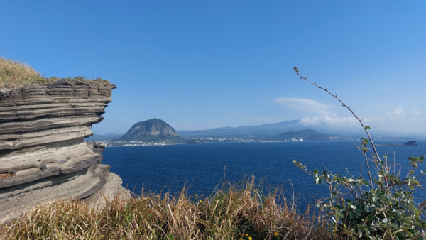 송악산 기암괴석 오른쪽으로 멀리 산방산과 한라산이 보인다. © 이봉수