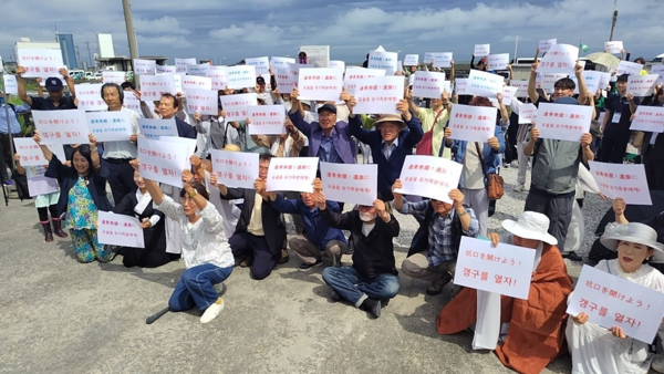 고교생을 포함한 한국과 일본의 시민 170명이 2024년 7월15일 '갱구를 열자'라고 쓰인 포스터를 들고 집회를 하고 있다. 가장 앞에 앉아 있는 이가 역사에 새기는 모임의 이노우에 요코 대표.