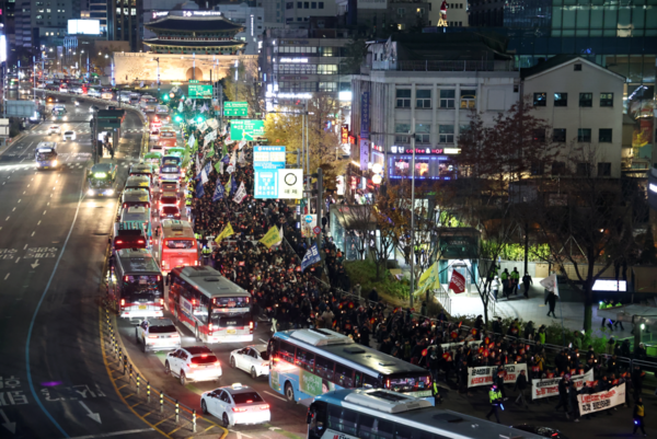 4일 오후 서울 동화면세점 앞에서 열린 '내란죄 윤석열 퇴진! 시민촛불'에서 전국민주노동조합총연맹 조합원을 비롯한 참석자들이 숭례문을 지나 용산 대통령실 방향으로 행진하고 있다. 2024.12.4. 연합뉴스