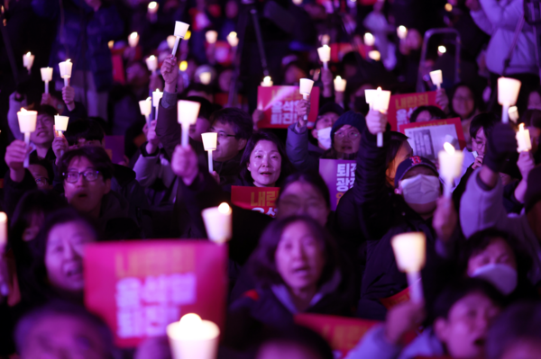 4일 오후 서울 동화면세점 앞에서 전국민주노동조합총연맹 주최로 열린 ‘내란죄 윤석열 퇴진! 시민촛불’에서 참가자들이 촛불을 들고 있다. 2024.12.4. 연합뉴스