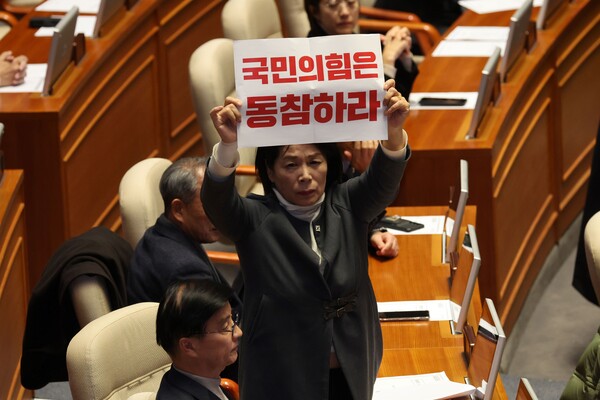 더불어민주당 최민희 의원이 7일 서울 여의도 국회에서 열린 본회의 개의에 앞서 국민의힘 의석 쪽을 향해 손팻말을 들어 보이고 있다. 2024.12.7. 연합뉴스