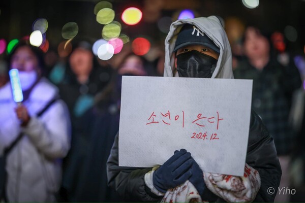 국회의사당 앞에서 열린 윤석열 탄핵 촛불집회에 참가한 여성이 '소년이 온다'는 문구를 들고 있다. 2024. 12.8. 사진 이호 작가