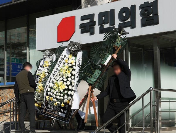 10일 대구 수성구 국민의힘 대구시당 앞에서 시당 관계자들이 시민들이 보낸 국민의힘 규탄 근조화환을 치우고 있다. 2024.12.10. 연합뉴스