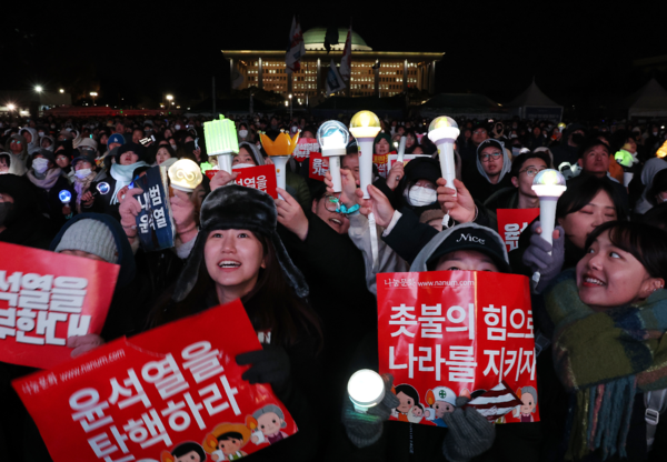 지난 7일 오후 서울 여의도 국회 앞에서 열린 '내란죄 윤석열 퇴진! 국민주권 실현! 사회대개혁! 범국민촛불대행진'에서 응원봉을 든 2030세대 참가자들이 탄핵안 통과를 촉구하고 있다. 연합뉴스