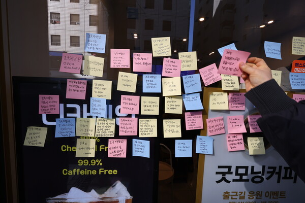  윤석열 대통령에 대한 두 번째 탄핵소추안 국회 표결일인 14일 조국혁신당 조국 전 대표가 선결제한 여의도의 한 카페에 시민들이 응원 메시지를 붙이고 있다. 2024.12.14. 연합뉴스