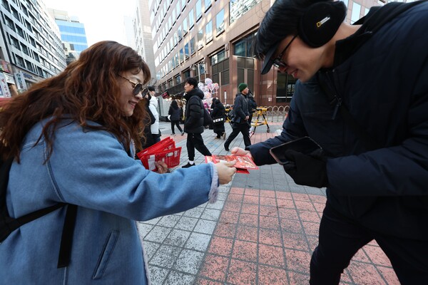 윤석열 대통령에 대한 두 번째 탄핵소추안 국회 표결일인 14일 서울 여의도 국회 앞 거리에서 한 시민이 무료로 핫팩을 나눠주고 있다. 2024.12.14. 연합뉴스