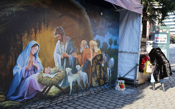 24일 서울 중구 명동성당을 찾은 시민들이 성탄 구유 그림 앞을 지나고 있다. 2024.12.24. 연합뉴스