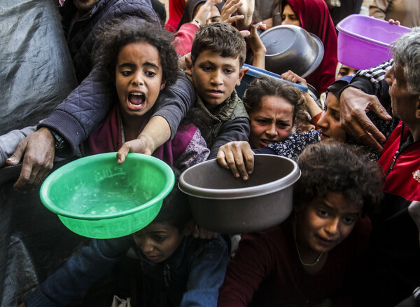 가자지구의 식량보급소에서 팔레스타인 사람들이 구호 식량을 받으려 애쓰고 있다. 2024.12..23 [신화=연합뉴스]