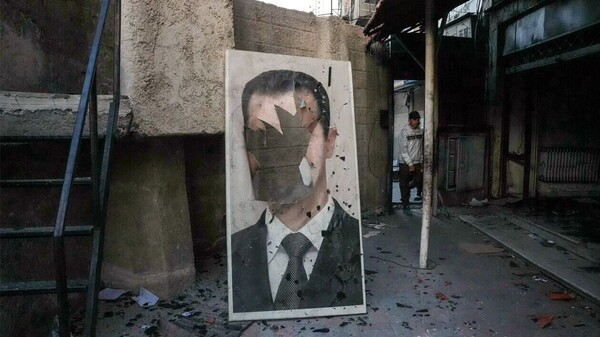 쫓겨난 시리아 대통령 아사드의 훼손된 사진. 2024.12. 9. AFP