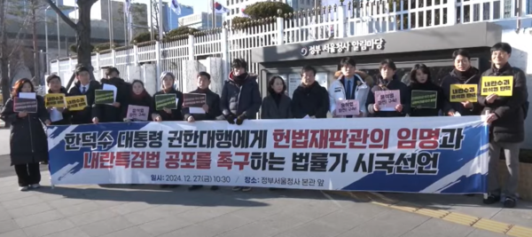 법학전문대학원 교수와 변호사, 노무사, 연구자 등 법률가 1224명이 27일 서울 종로구 정부서울청사 정문 앞에서 한덕수 대통령 권한대행에게 헌법재판관 임명과 내란 특검법 공포를 촉구하는 시국선언 기자회견을 열고 있다. MBC 중계 화면 갈무리