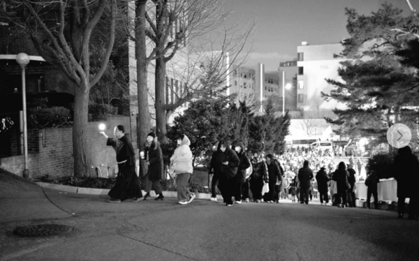 꼰벤뚜알 프란치스코 수도회 한 수사가 응원봉을 들고 수도원 여자화장실에서 길게 줄을 거서 기다리는 이들을 다른 화장실로 안내하고 있다. © 엑스 'muriyanan'