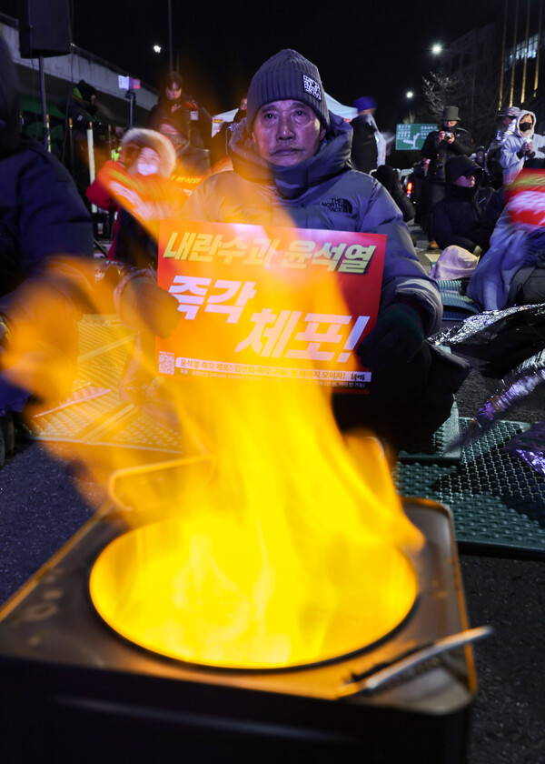 9일 오후 서울 용산구 한남동 대통령 관저 인근에서 열린 윤석열 대통령 탄핵 촉구 집회에서 한 참가자가 팻말을 들고 있다. 2025.1.9. 연합뉴스