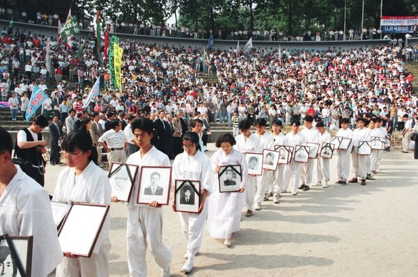 1994년 6월 11일 한양대 노천극장에서 열린 '민족민주 열사 범국민추모제 및 6월항쟁 기념대회'에서 유가족과 학생들이 민주화과정에서 숨진 민주열사 116명의 영정을 들고 식장으로 들어서고 있다. 1994.6.11. 연합뉴스 자료사진