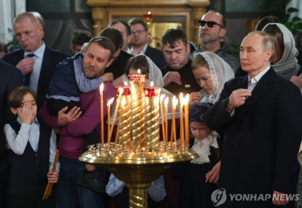 러시아 푸틴 대통령(맨 오른쪽)이 지난 7일 모스크바 승리공원 인근 교회에서 열린 성탄절 예배에 참석해 기도하고 있다. AFP=연합뉴스