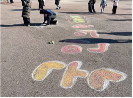 여의도광장에 분필아트로 ‘국민의힘 해체’를 새겨 넣은 시민 및 예술인. (2024년 12월 14일)