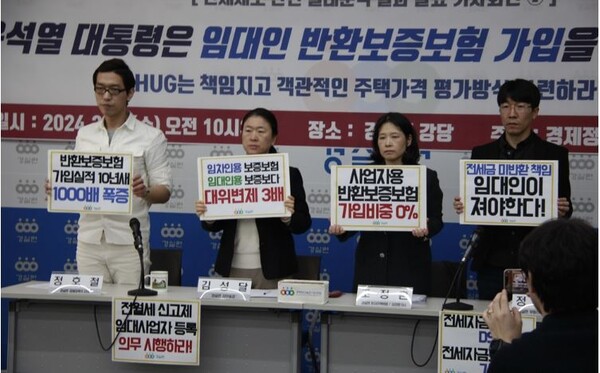 경제정의실천시민연합의 정호철 경제정책국 간사와 김성달 사무총장 등이 27일 오전 경실련 강당에서 전세보증금 반환보증보험 실태분석 발표 기자회견 중 피켓을 들고 있다. [경실련]