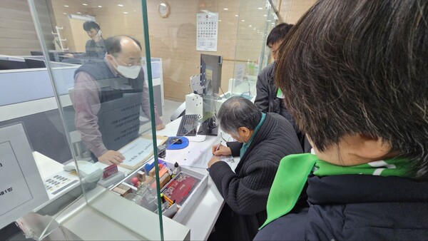 헌재 민원 창구에서 탄원서 접수 절차를 밟고 있는 60+기후행동 대표단.