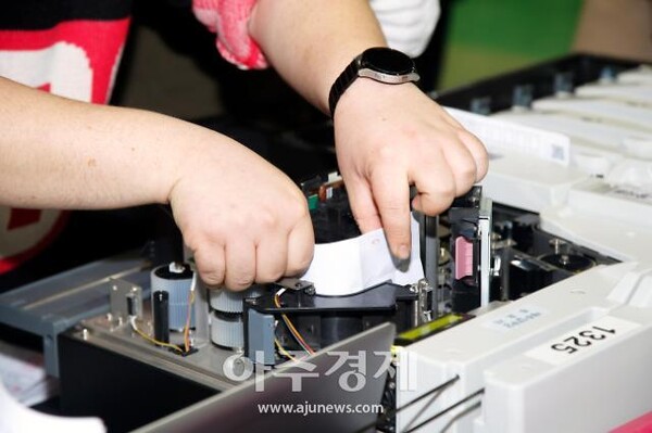 2022년 대통령선거 당시 투표지분류기에서 걸림 현상이 발생하여 개표사무원이 손작업으로 투표용지를 뽑아내고 있다. 아주경제.