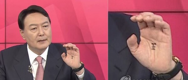 국민의힘 대권주자인 윤석열 전 검찰총장이 TV토론회 당시 손바닥 한가운데에 '왕(王)'자를 그려놓은 장면이 카메라에 포착됐다. 2일 온라인 커뮤니티에는 지난 세 차례 TV토론회에서 임금을 뜻하는 한자 '왕'자가 그려진 윤 전 총장의 손바닥을 캡처한 사진이 나돌았다. 지난 1일 MBN 주최로 열린 5차 TV토론회에서 윤 전 총장이 홍준표 의원과의 1대1 주도권 토론에서 손을 흔드는 제스쳐를 하면서 손바닥에 적힌 '왕'자가 선명하게 포착됐다. 윤 후보 측은 후보와 같은 아파트에 사는 지지자들이 토론이 있을 때마다 응원한다는 뜻에서 손바닥에 적어주신 것이라고 밝혔다. 2021.10.2 [MBN 유튜브 캡처. 연합뉴스