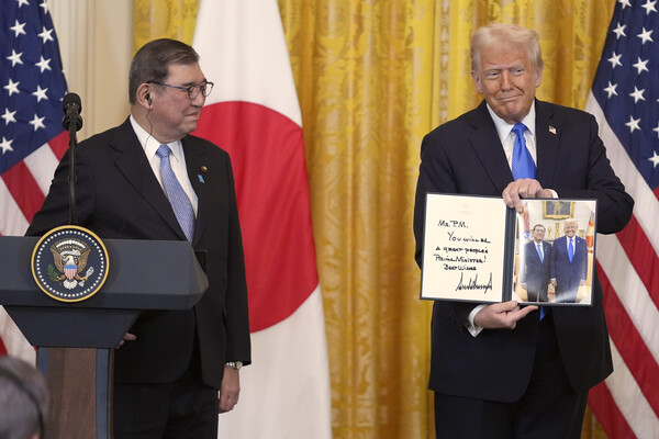 도널드 트럼프 대통령(오른쪽)이 7일 워싱턴 백악관에서 열린 기자회견에서 이시바 시게루 일본 총리에게  함께 찍은 사진을 선물하고 있다. 2025.2.7. AP 연합뉴스